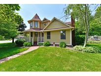 Charming two-story home with a turret, lush green lawn, and a welcoming brick pathway at 1010 Lakewood N Dr, Brownsburg, IN 46112