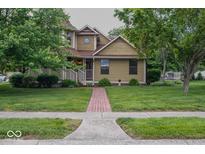 Charming two-story home with a well-manicured front yard, mature trees, and inviting front porch at 1010 Lakewood N Dr, Brownsburg, IN 46112