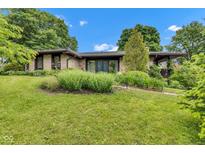 Charming stone home featuring a well-manicured lawn and beautiful landscaping at 10444 N State Road 9, Fountaintown, IN 46130