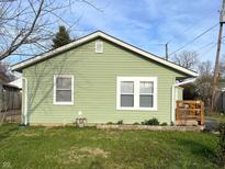 Charming exterior featuring sage green siding, white trim and a small porch with wooden rails and address numbers at 1801 Bauer Rd, Indianapolis, IN 46218