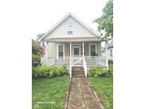 Charming home featuring a cozy front porch, a well-manicured lawn, and inviting curb appeal at 208 E Madison E St, Alexandria, IN 46001