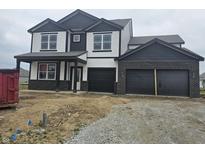 Striking two-story home with black and white accents, a covered porch, and a three-car garage at 2271 Oakmont Dr, Plainfield, IN 46168