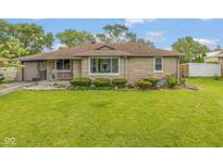 Charming single-story home with stone facade, well-manicured lawn, and mature landscaping at 2445 S Bolton Ave, Indianapolis, IN 46203