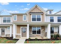 Inviting two-story home with a covered front porch, stone accents, and manicured landscaping at 3927 Wren Dr, Brownsburg, IN 46112