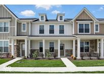 Inviting townhome with stone accents, covered porch, and lush landscaping at 3947 Wren Dr, Brownsburg, IN 46112
