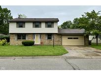 Charming two-story home with brick and siding, a well-maintained lawn, and an attached one-car garage at 5130 Navajo Ct, Columbus, IN 47203