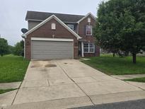 Traditional two-story brick home featuring an attached two-car garage and extended concrete driveway at 615 Albermarle Dr, Pittsboro, IN 46167