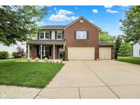Charming two-story home with brick and siding, a well-manicured lawn, and a three-car garage at 7312 Drum Castle Ct, Indianapolis, IN 46259