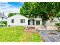 Charming single-story home with a well-maintained lawn, beautiful landscaping, and a stone walkway at 7414 Mendenhall Rd, Camby, IN 46113