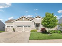 Charming home featuring a beautifully landscaped yard and a three-car garage, plus a stone-accented facade at 9656 Summerton Dr, Fishers, IN 46037