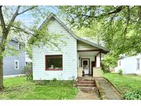 Charming home featuring an inviting front porch, complemented by mature trees, and an access ramp at 1106 W 4Th St, Anderson, IN 46016