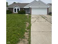Charming single-story home with a two-car garage and tidy front yard featuring green bushes at 2717 N Rural St, Indianapolis, IN 46218