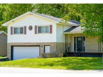 Charming home with a two-car garage and stone facade, nestled among mature trees at 2721 W 34Th St, Anderson, IN 46011