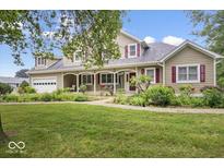 Beautiful home showcasing a manicured lawn, welcoming porch, and attached garage at 2971 N Buck Creek Rd, Greenfield, IN 46140