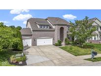 Charming brick home featuring a three-car garage and manicured front lawn at 543 Amersham Ct, Avon, IN 46123