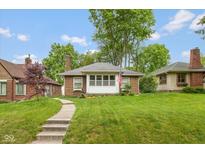 Charming brick home featuring a well-manicured lawn and inviting walkway at 5616 Winthrop Ave, Indianapolis, IN 46220