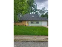 Charming single-story home with a well-manicured lawn and a bright yellow front door at 6117 Marilyn Rd, Indianapolis, IN 46226