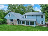Charming home exterior featuring light blue siding, stone accents and lots of bright windows at 6430 E Southport Rd, Indianapolis, IN 46237