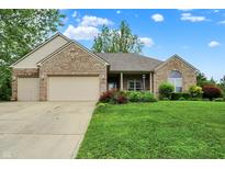 Charming single-story brick home featuring a well-manicured lawn and a two-car garage at 7310 Monaghan Ln, Indianapolis, IN 46217