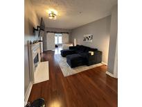 Spacious living room featuring a fireplace, TV, dark blue sectional sofa, and sliding barn doors at 7601 Newport Bay Dr # 203, Indianapolis, IN 46240