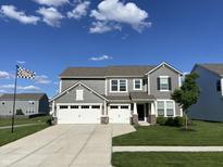 Charming two-story home with a three-car garage and a well-maintained lawn and beautiful blue skies at 8876 Boylan Pl, Pendleton, IN 46064