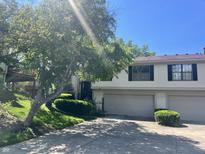 Traditional home with two-car garage, manicured lawn, mature trees, and a sunny sky at 9560 Bay Vista E Dr, Indianapolis, IN 46250