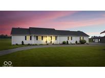 Charming home with a well-maintained lawn and a long driveway, set against a vibrant sunset backdrop at 9605 W 100 S, Jamestown, IN 46147