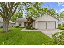 Charming single-story home featuring a manicured lawn, two-car garage, and inviting curb appeal at 975 Atir Ln, Greenfield, IN 46140