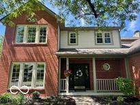 Charming two-story brick home featuring large windows and a welcoming front porch at 10501 Greenway Dr, Fishers, IN 46037