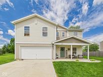 Charming two-story home boasts a well-manicured lawn, welcoming front porch, and attached two-car garage, perfect for Gathering living at 1117 Oregon Way, Anderson, IN 46012