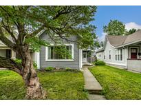 Charming gray home featuring a well-maintained lawn and mature tree, creating curb appeal at 1418 Olive St, Indianapolis, IN 46203
