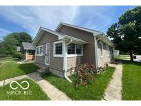 A charming single-Gathering home with well-kept lawn and tidy flower bushes at 1527 Main St, Beech Grove, IN 46107