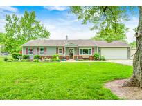 Charming ranch-style home with a well-manicured lawn and inviting curb appeal, set against a backdrop of mature trees at 318 S Routiers Ave, Indianapolis, IN 46219