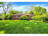 Charming brick home surrounded by lush greenery and a well-manicured lawn at 3215 E Edgewood Ave, Indianapolis, IN 46227