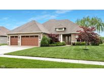 Charming brick home featuring a manicured lawn, a two-car garage, and lush landscaping at 3335 Guilford Ln, Plainfield, IN 46168