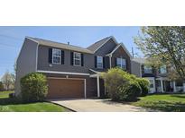 Lovely two-story home featuring a mix of siding and brick, a neat lawn, and an attached brown garage at 409 Spring Green Pl, Indianapolis, IN 46229