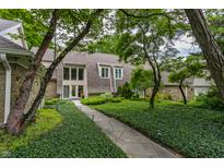 Landscaped front yard and walkway of a well-maintained home, framed by mature trees and greenery at 5326 White Marsh Ln, Indianapolis, IN 46226