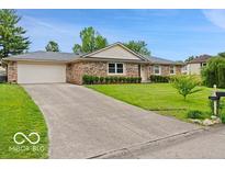 Charming brick ranch-style home features an attached two-car garage and a well-maintained front yard at 813 Boulder Rd, Indianapolis, IN 46217