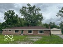 Charming brick home featuring a well-maintained lawn and a detached two car garage at 907 Monroe St, Indianapolis, IN 46229
