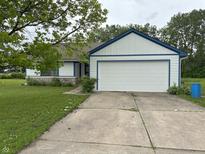 Charming home with a two-car garage, blue trim, and a well-maintained front yard at 9730 English Oak Pl, Indianapolis, IN 46235