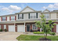 Inviting townhome with brick and siding exterior, attached garage, and well-maintained front yard landscaping at 9771 Blue Violet Dr, Noblesville, IN 46060