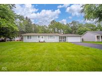 Charming single-story home features a well-manicured lawn, white trim, and an attached two car garage at 10097 N Balfer E Dr, Fortville, IN 46040