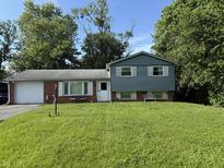 Charming two-story home with a well-manicured lawn and a mix of brick and siding exterior at 10106 E 21St St, Indianapolis, IN 46229