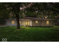 Charming single-story home featuring a lush green lawn and beautiful mature trees at 11123 Haverstick Rd, Carmel, IN 46033