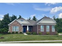 Beautiful brick and stone home with a manicured lawn and mature trees at 11700 Harvest Moon Dr, Noblesville, IN 46060