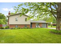 Charming two-story home featuring a well-manicured lawn, brick accents, and a comfortable front porch seating area at 1440 Fenwick Ave, Indianapolis, IN 46219