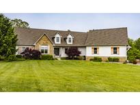 Charming home featuring a stone facade, dormer windows, and a well-manicured lawn at 1820 N 1100 E, Sheridan, IN 46069