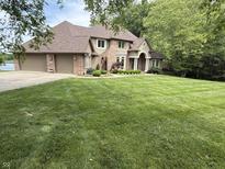A brick two-story house with an attached garage sits on a large, well-manicured lawn surrounded by mature trees at 2925 N Country Club Rd, Martinsville, IN 46151