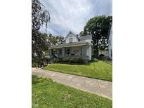 Charming two-story home with a covered porch and well-maintained lawn at 303 Walnut St, Greenfield, IN 46140