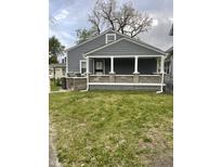 Charming home featuring gray siding, a covered porch with white columns and stone accents at 3636 Crescent Ave, Indianapolis, IN 46208